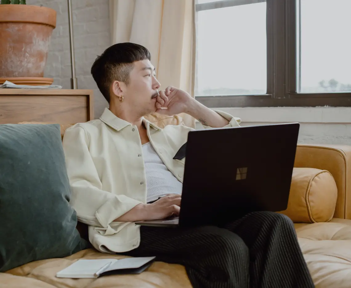 Man thinking behind laptop